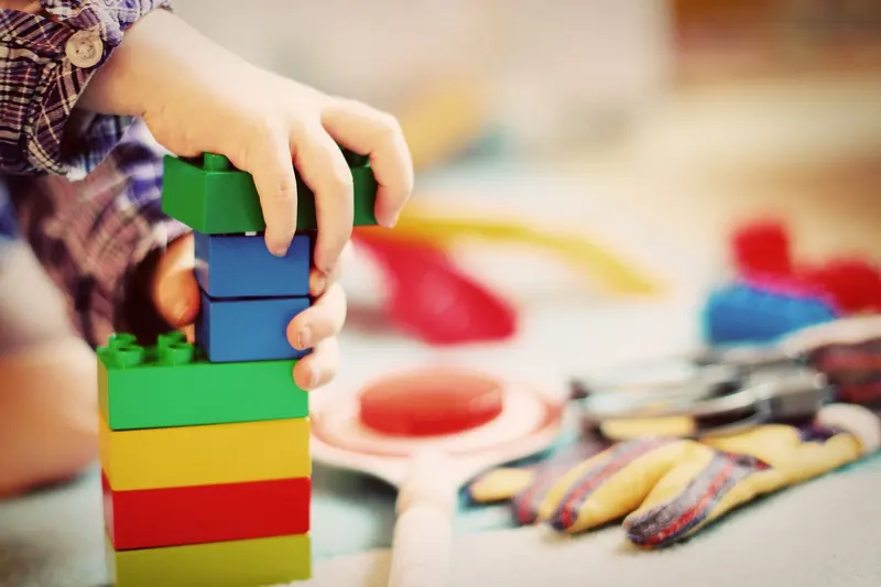 Enfant TSA jouant avec des objets de jeu pour apprendre à gérer le stress